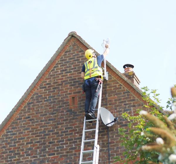 One of Wessex Internet’s workers installing full fibre business broadband on the roof of a residential building.
