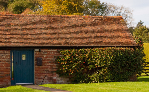 A farmhouse building with blue door that hosts Hotbox Studios in Hook, South West England.
