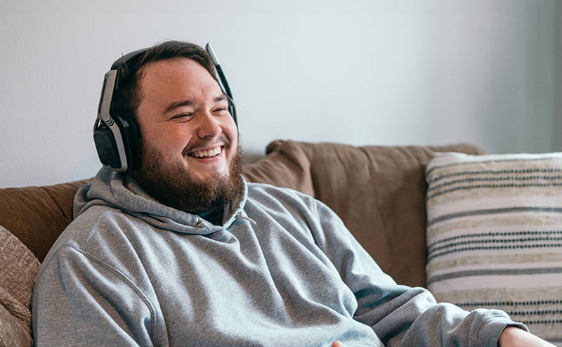 Male sat on a sofa wearing a gaming headset